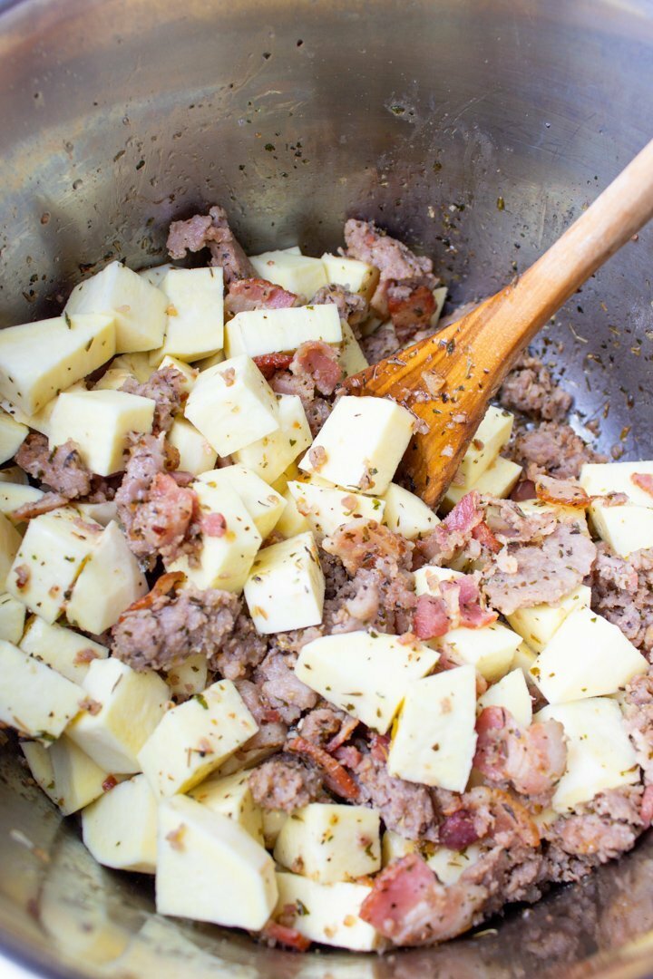 Browned bacon and ground pork, with raw white sweet potatoes in an Instant Pot.